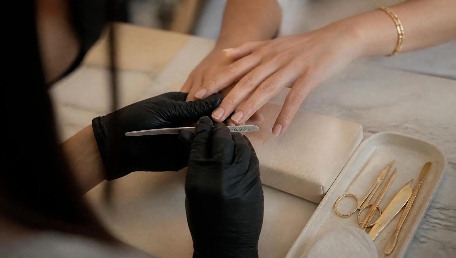 Manicurist filing nails at a marble station